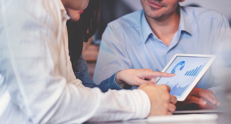 Business people working on financial data on a digital tablet.